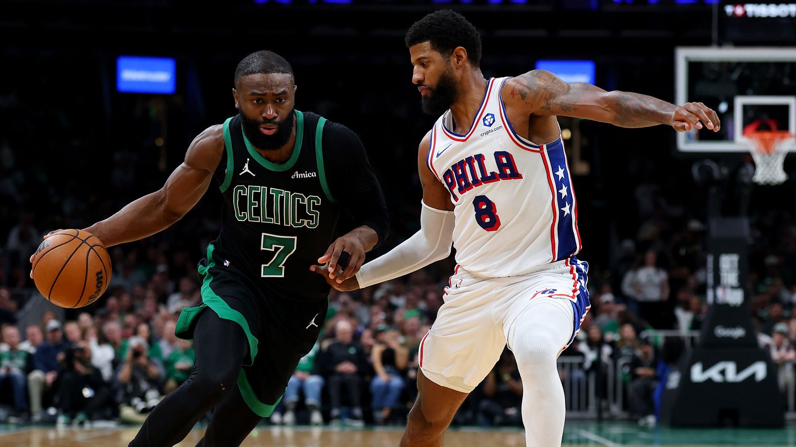 Jaylen Brown, in a black Celtics alternate uniform, drives against Paul George of the Philadelphia 76ers at TD Garden.