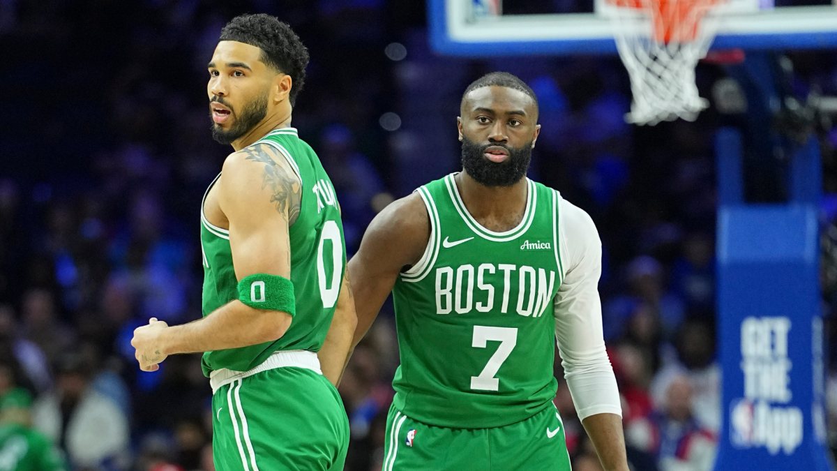 Jayson Tatum and Jaylen Brown stand side by side on the court in Celtics road uniforms.