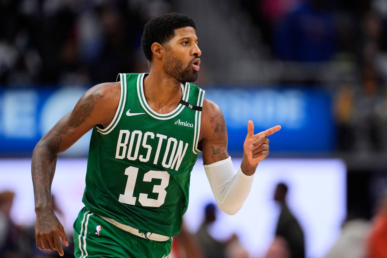 Paul George, in a green Celtics road uniform, points after hitting a shot against the Pistons in Detroit.