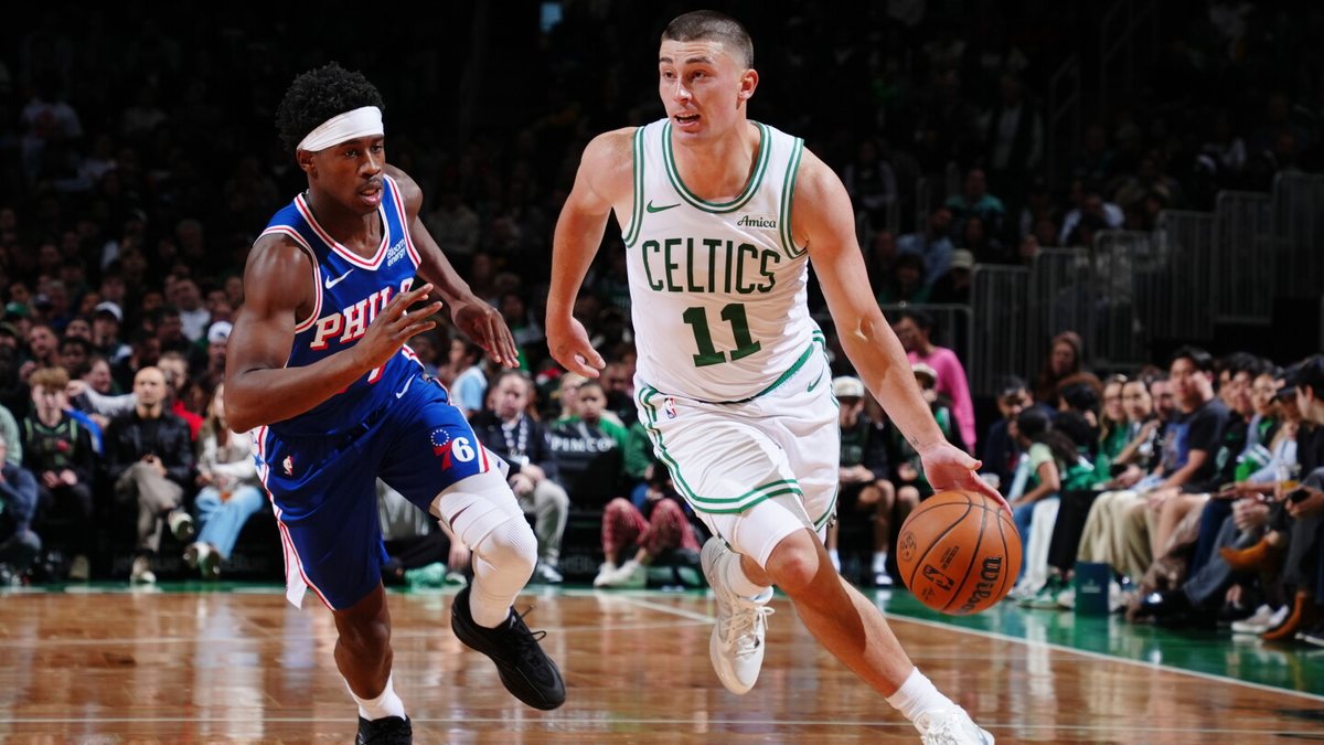 Payton Pritchard drives with the ball against a Philadelphia 76ers defender at TD Garden.